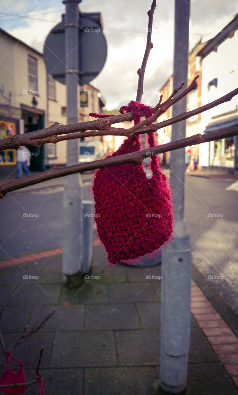 A red yarn heart leaf on a tree in my town