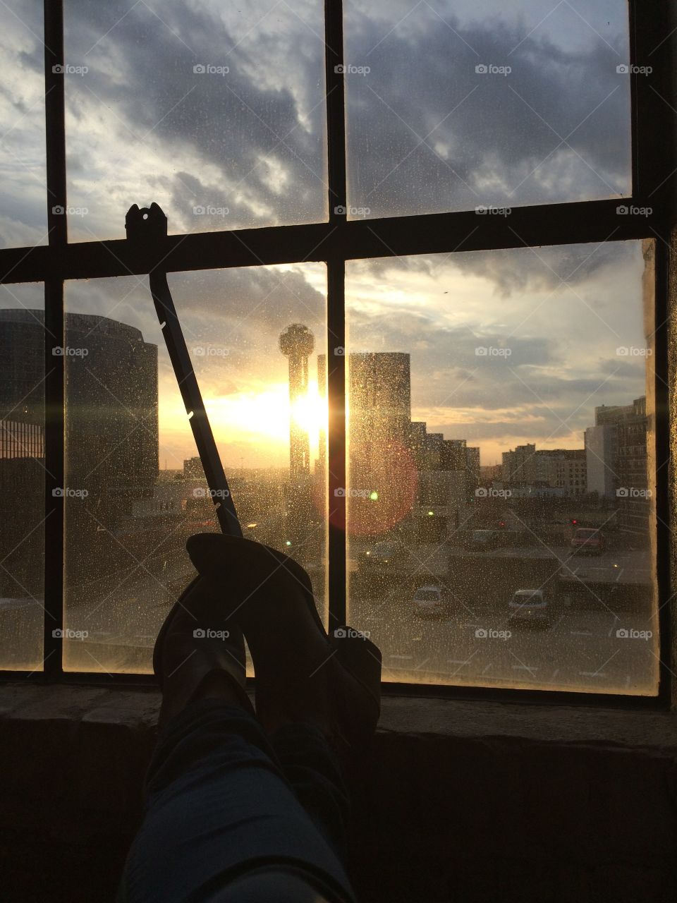 Cowgirl boots in the loft windows of a downtown Dallas hotel at sunset. 