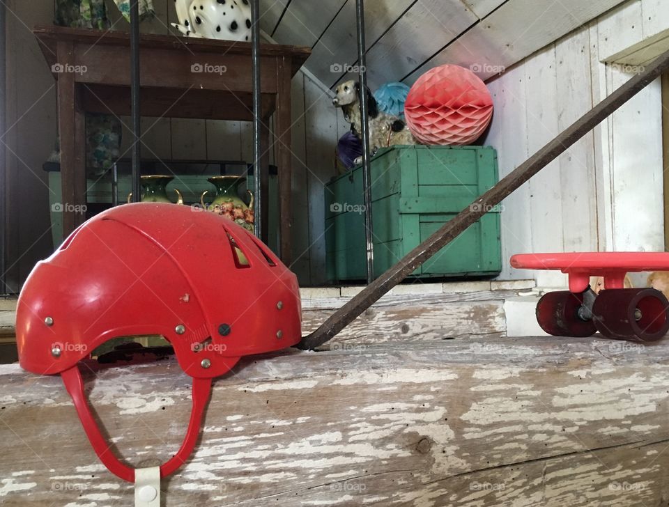 Red helmet and wheels on an attic.