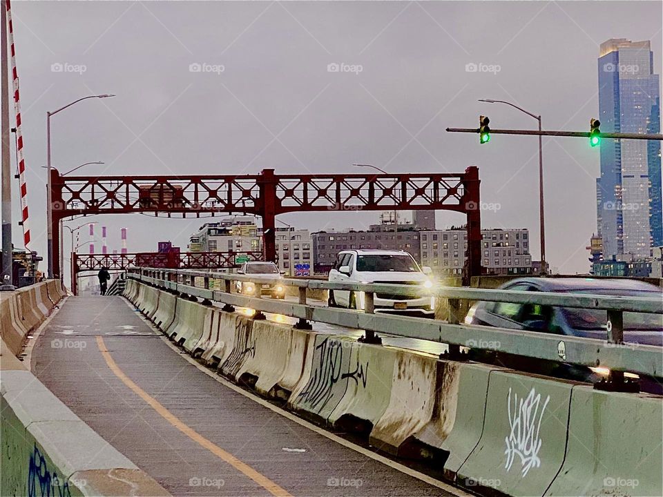 From the pedestrian lane of the „Pulaski Bridge“ you can see a lot of activity. The car lanes are in the center and the double sided bicycle lane is to the right. Our trip leads from „Greenpoint“, Bklyn to LIC, Queens. 2023. Hypnotic Productions