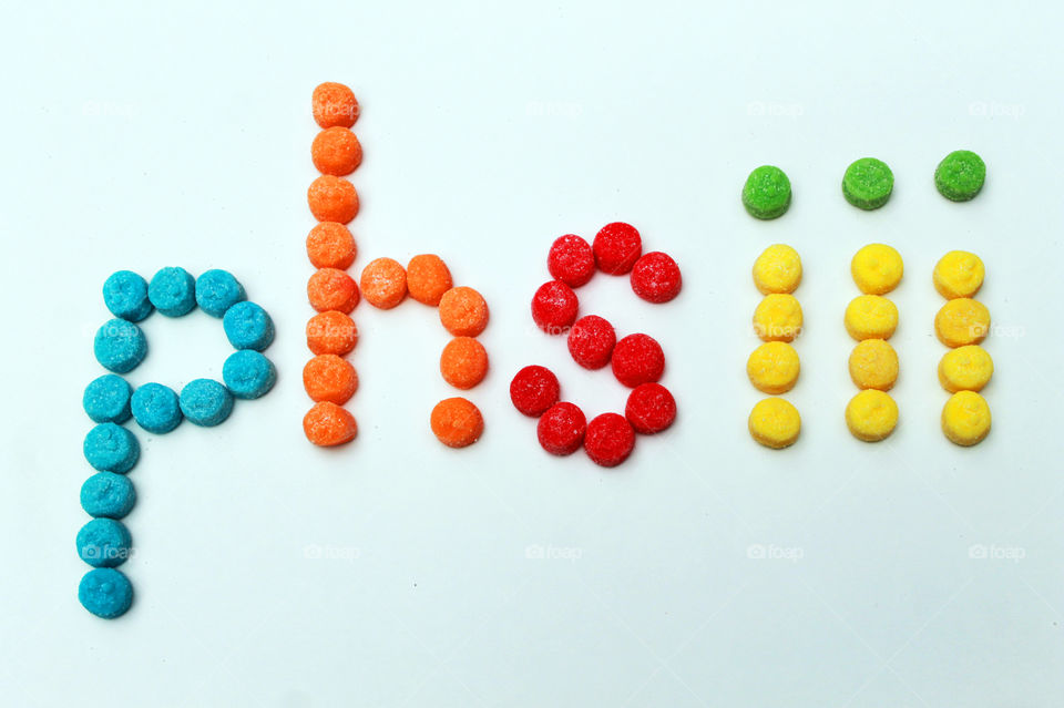 My photographer name, phsiii, is spelled out in sour,chewy gummies in shades of turquoise, orange, red, yellow & green; all on a white background. π