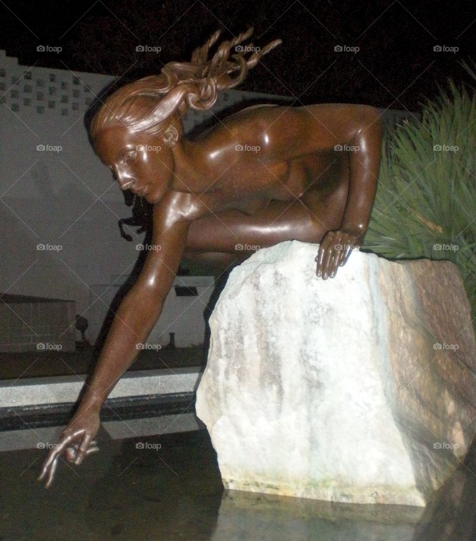 female sculpture . touching water 