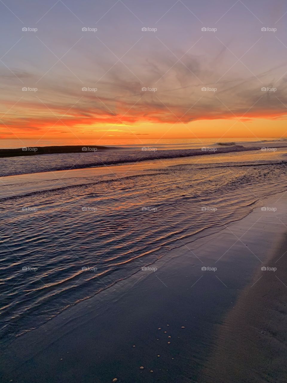 Spectacular sunset over the Gulf of Mexico. The descending sunset cast multiple colors across the Gulf of Mexico and the surrounding beach