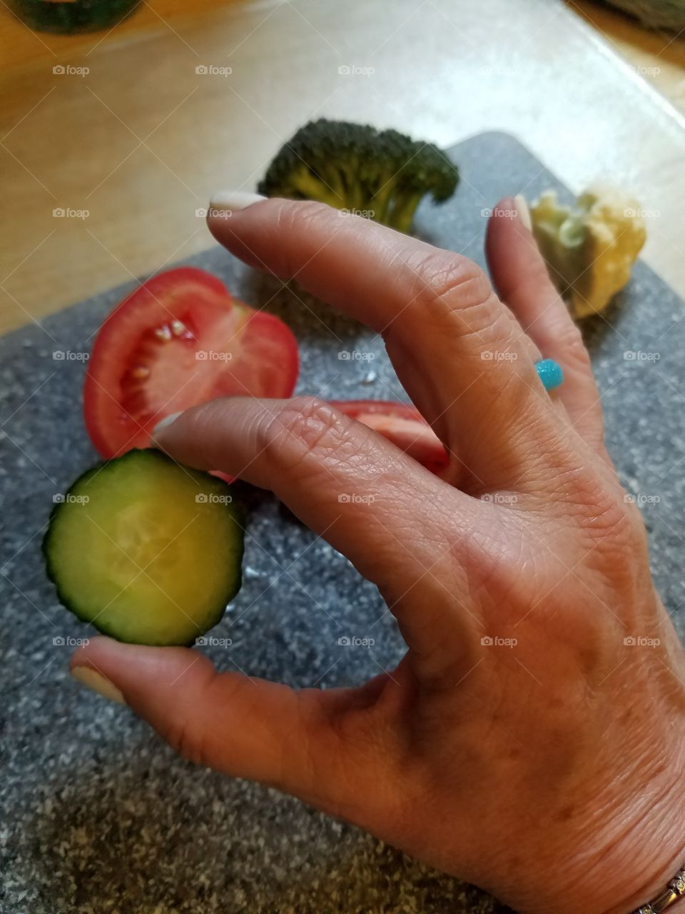 Holding food A ok cucumber and tomato