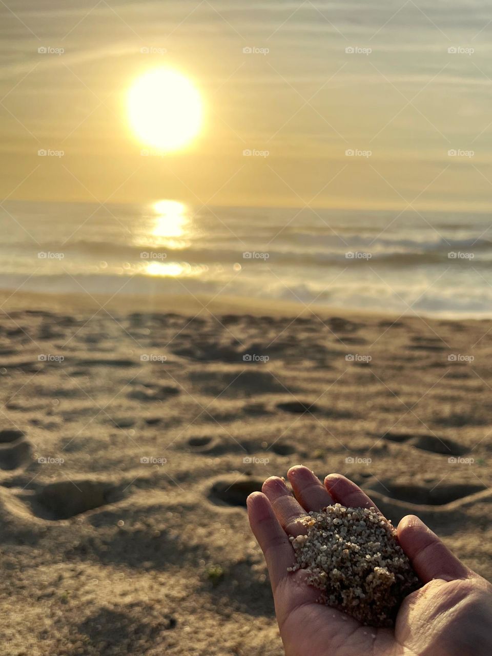 Sand in hand by the beach 