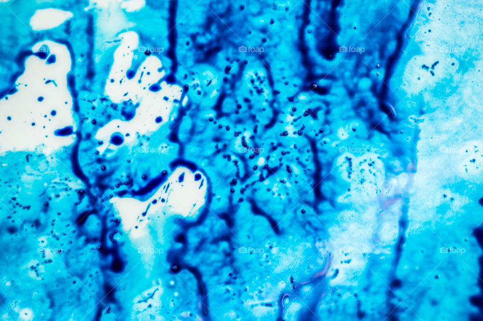 The ink to refill the printer cartridge was spilled onto the white washbasin and the paints blended into abstract drips and patterns.