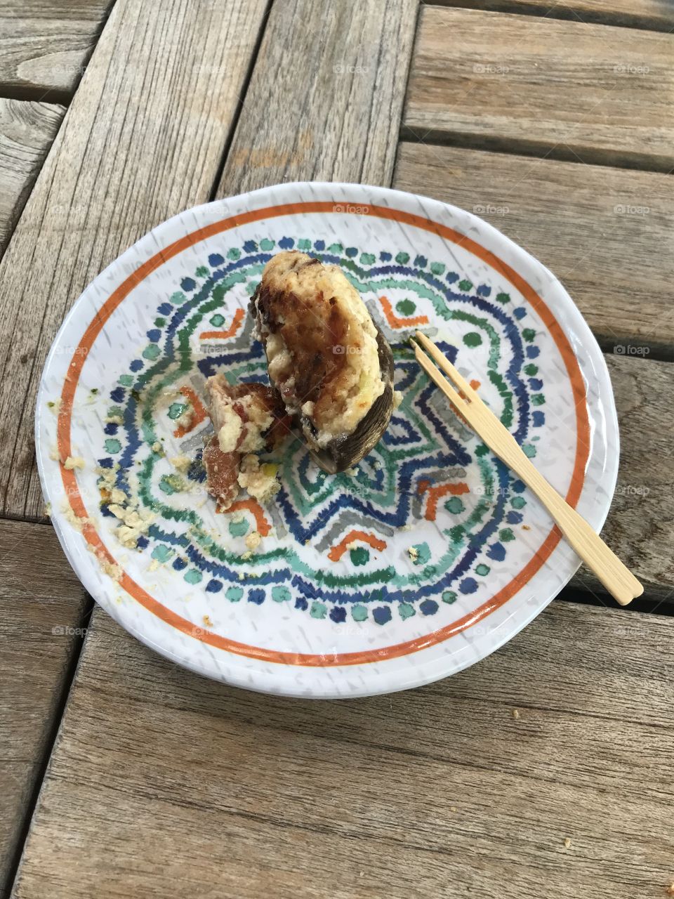 A small appetizer prior to dinner. It is a mushroom with other edibles in it. This piece of food tastes delicious.