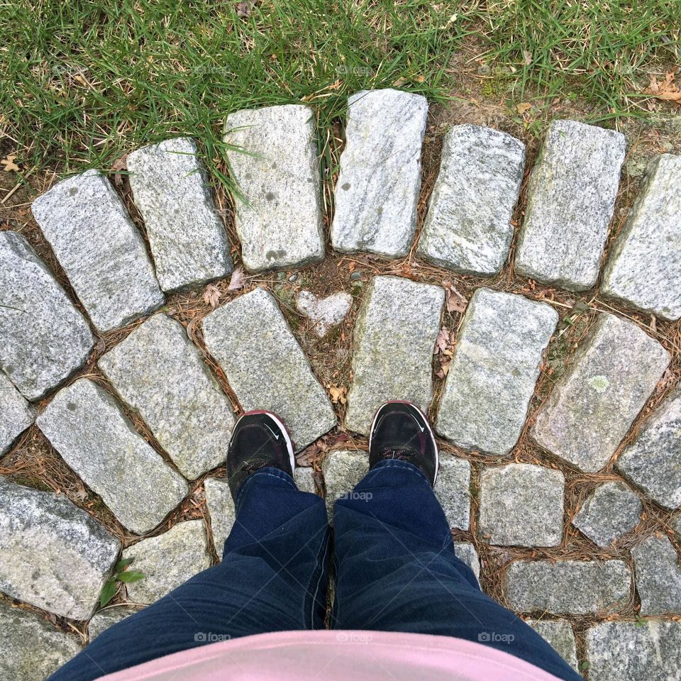 Standing on cobblestone entry. Heart shaped rock in center of cobblestones. Grass is green, it's a beautiful day. what a great place to be & watch everything.Looking down where I'm standing.