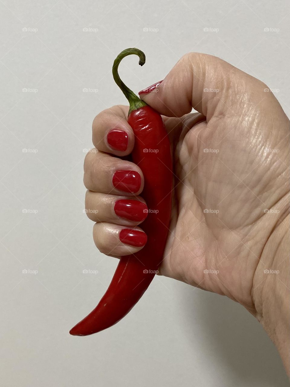 Hand holding red pepper 