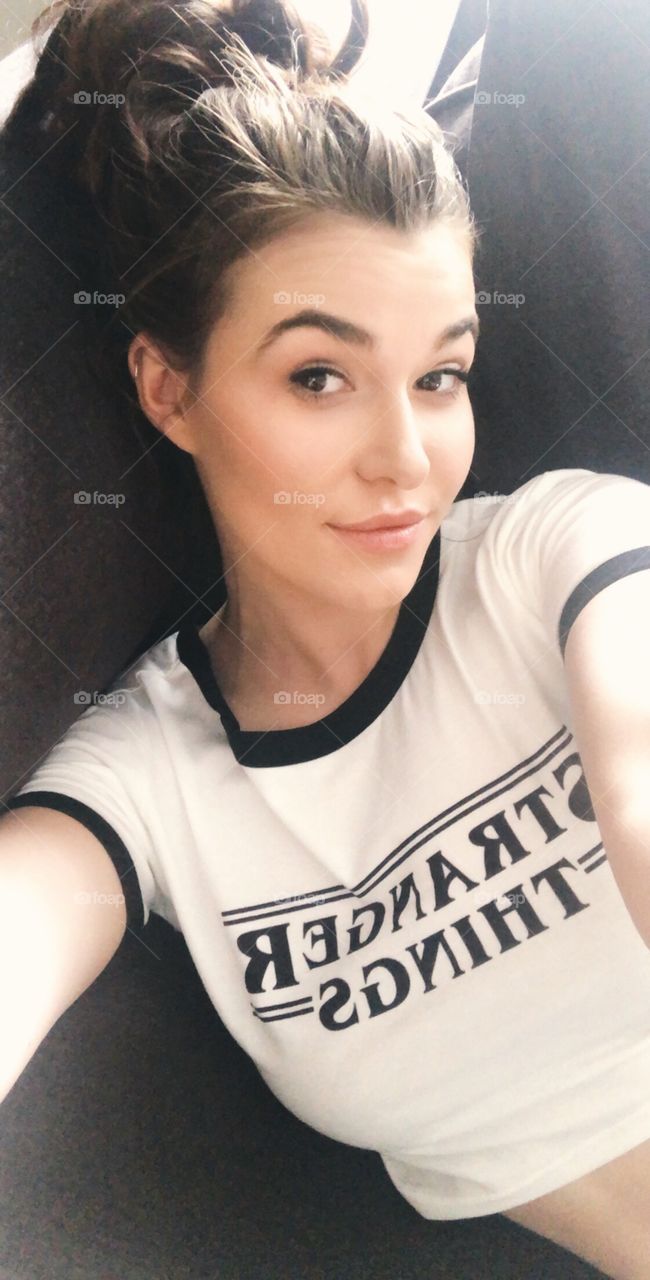Selfie of a brunette college girl in a pop culture tv show T-shirt. 
