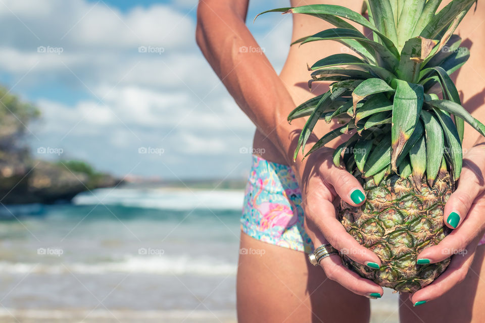 Woman sexy body with pineapple. Bali island.