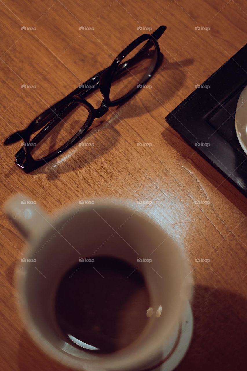 Black frame Glasses and cup of coffee