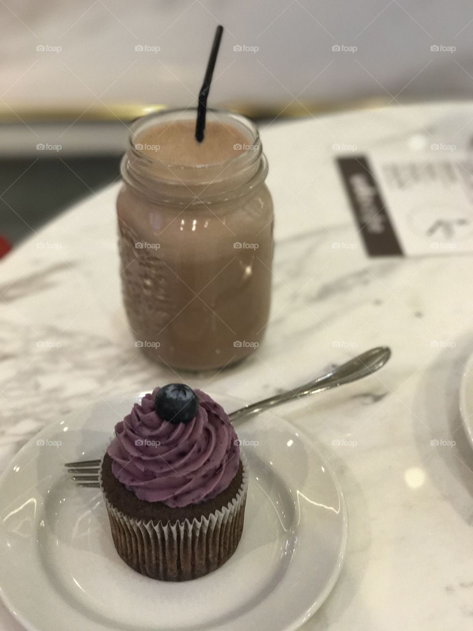 Hot beverage cocoa and  blueberry cupcake .