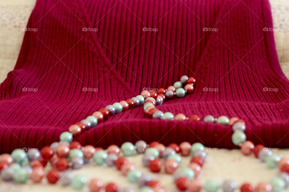 Magenta sweater and colorful pearl necklace