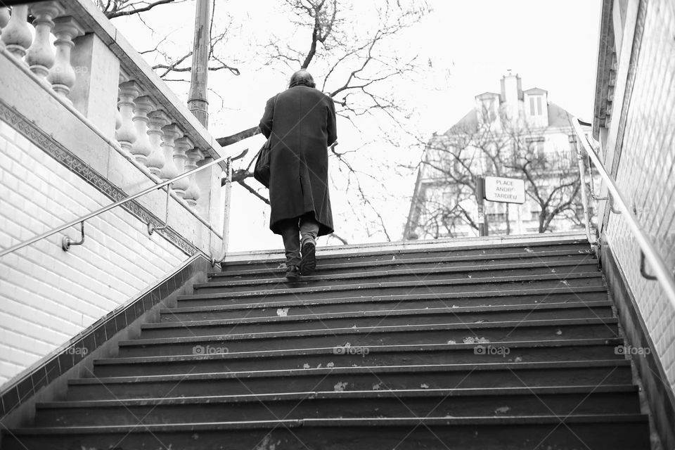 Lonely man in long coat waiting up the stairs. Autumn season 