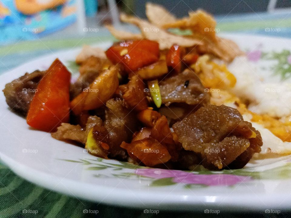Stir-fry beef with soy sauce with tomato, chili, and shallots