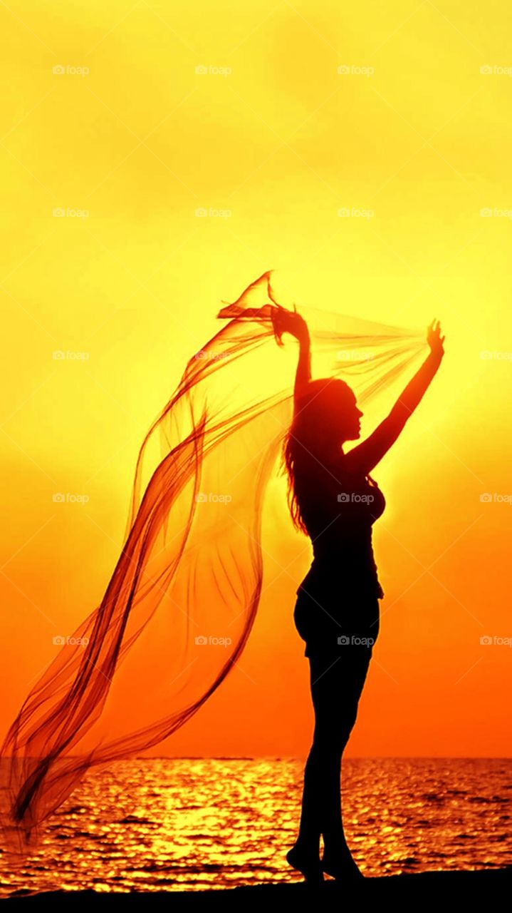 Woman dancing with a beautiful sunset 