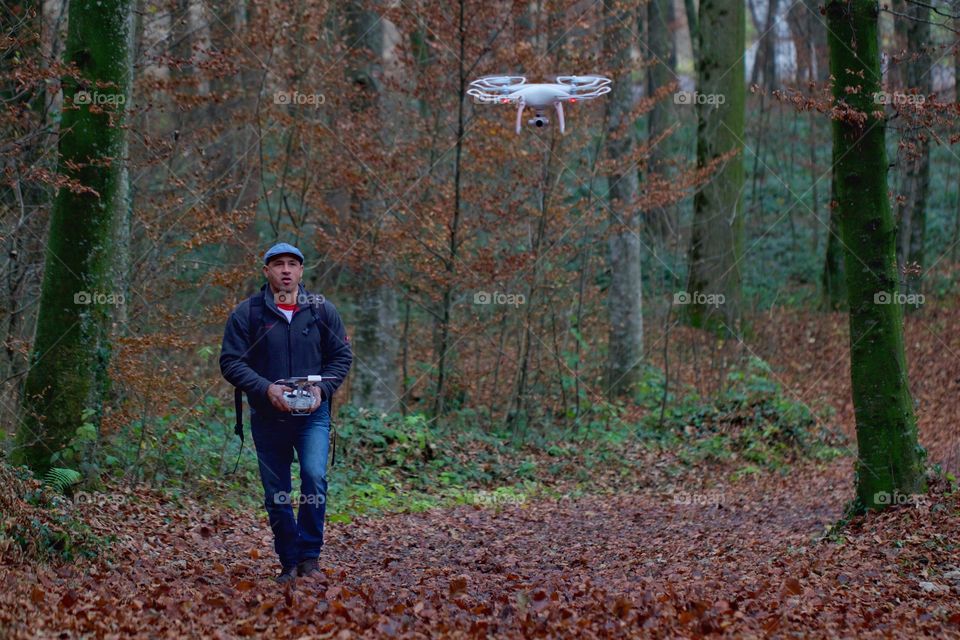 Man walking in forest with rotating drone camera