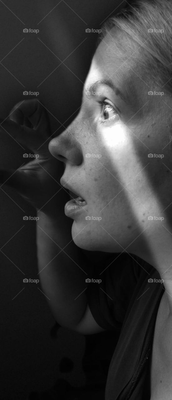 black and white photo of a girl looking out the window