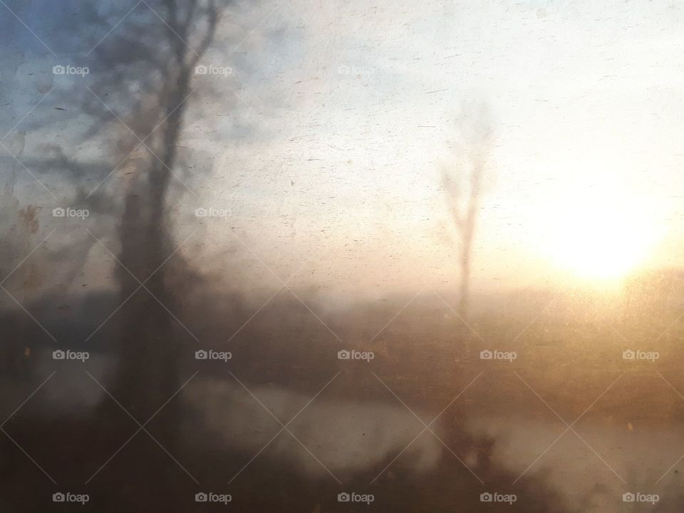 a view of the sunset through the window of the old passenger wagon