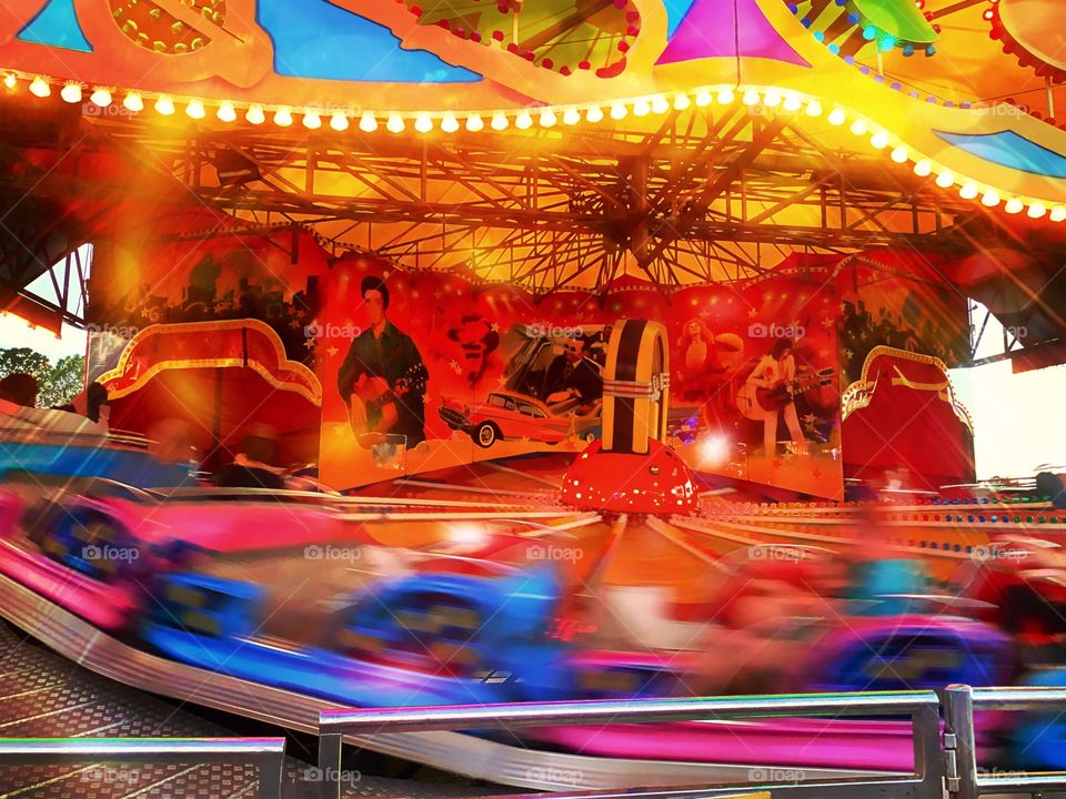 A ride at the fair going so fast it leaves a blur.