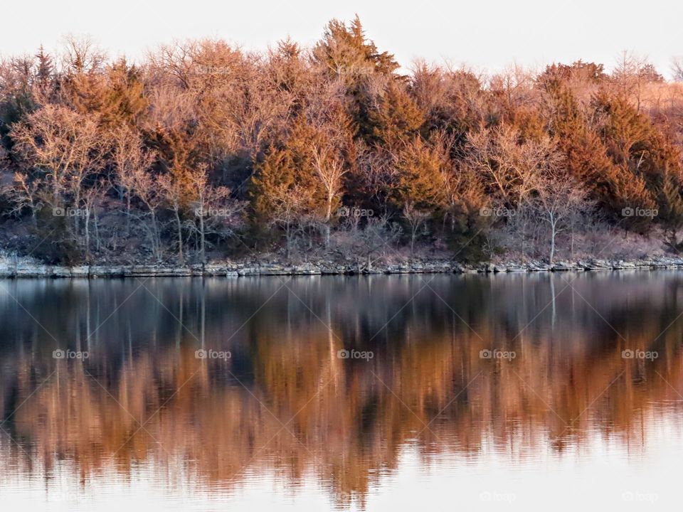 Stunning reflection over calm waters. Colorful trees are budding.