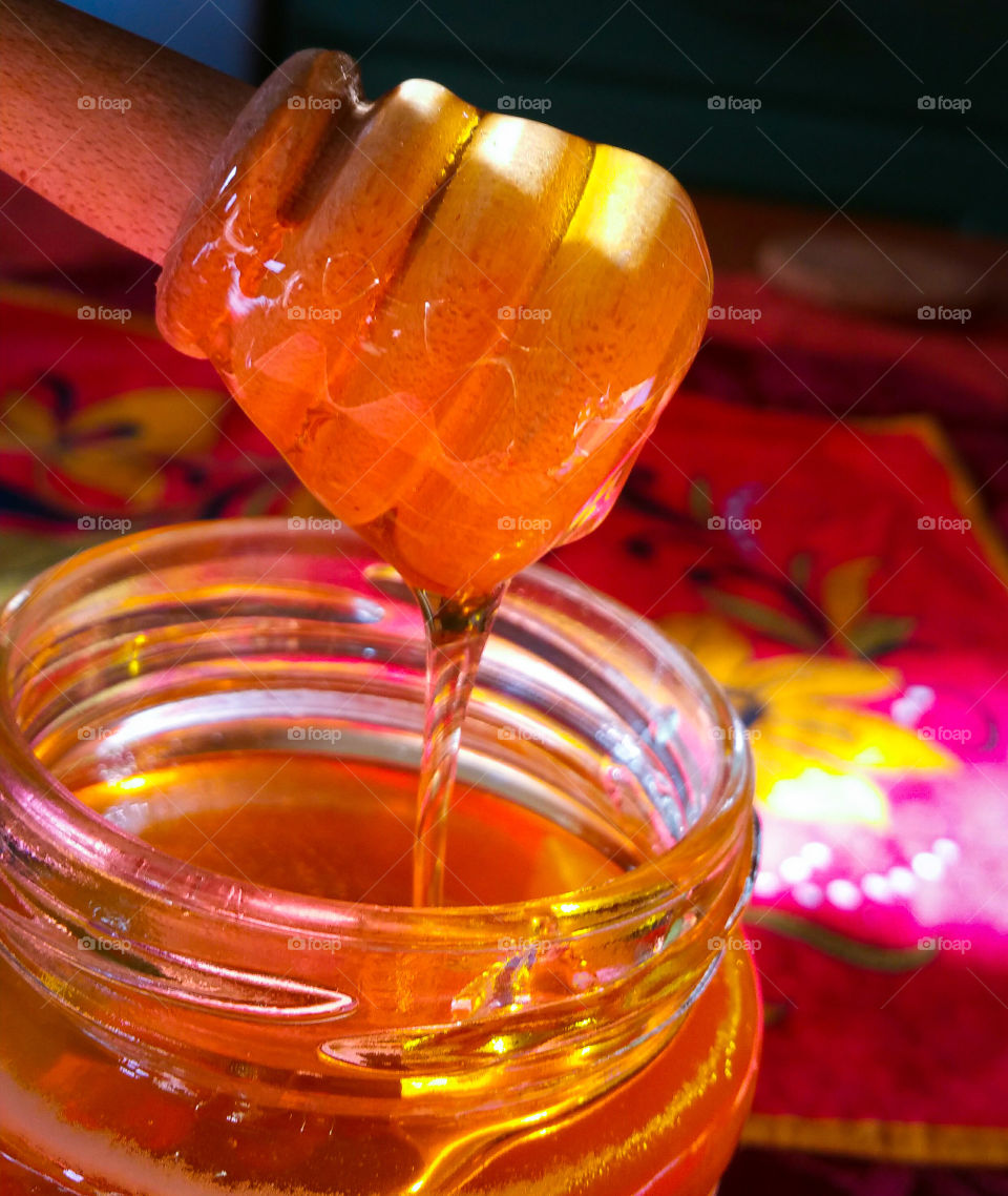 Honey in a glass jar with a wooden spoon