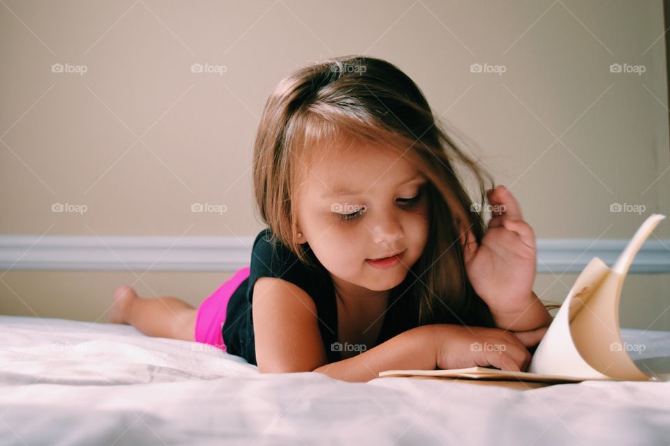 Girl on bed reading book