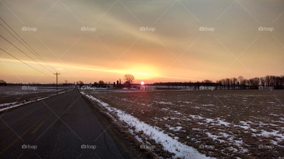 A Beautiful country sunrise with a bit of snow left on the ground.