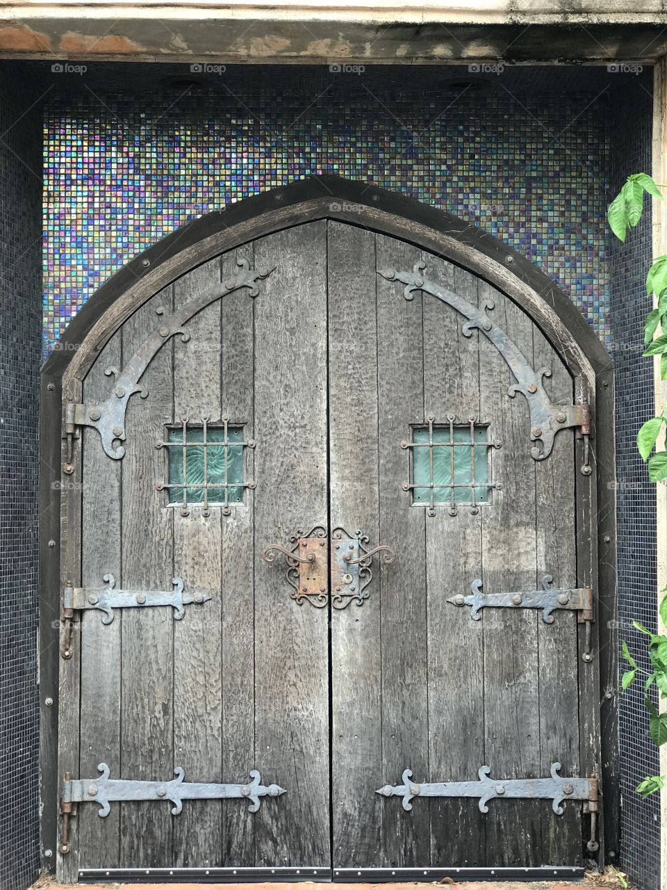 Symmetrical antique weathered arched wooden doors 