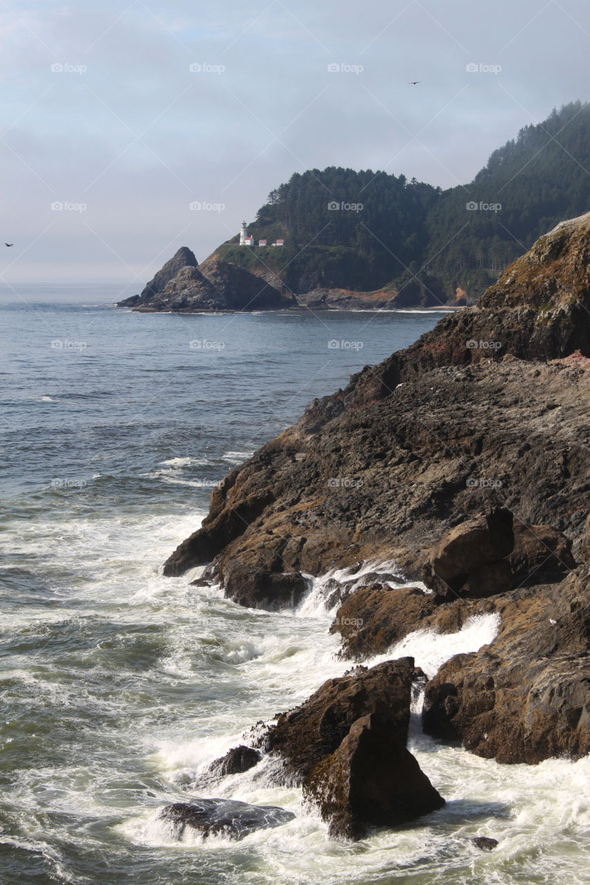 Lighthouse in distance at the Sea Lion Cave near Florence, Oregon