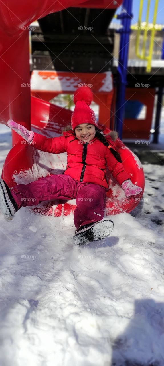 little girl in the park in the spring on the slide