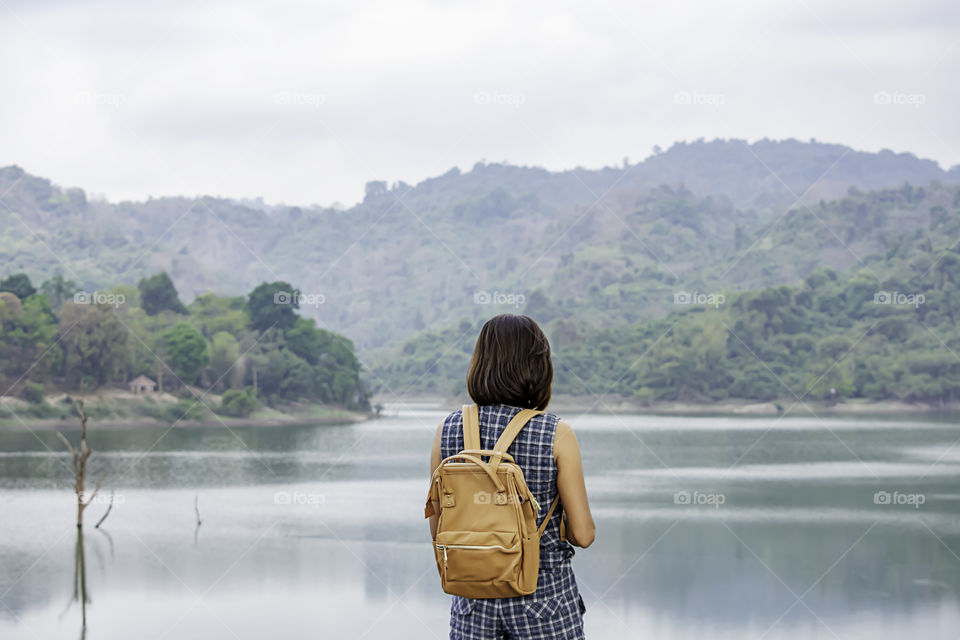 Women shoulder backpack Background mountains and water at Wang Bon dam Nakhon nayok , Thailand