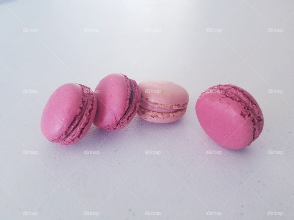 Pink macarons on a white surface.