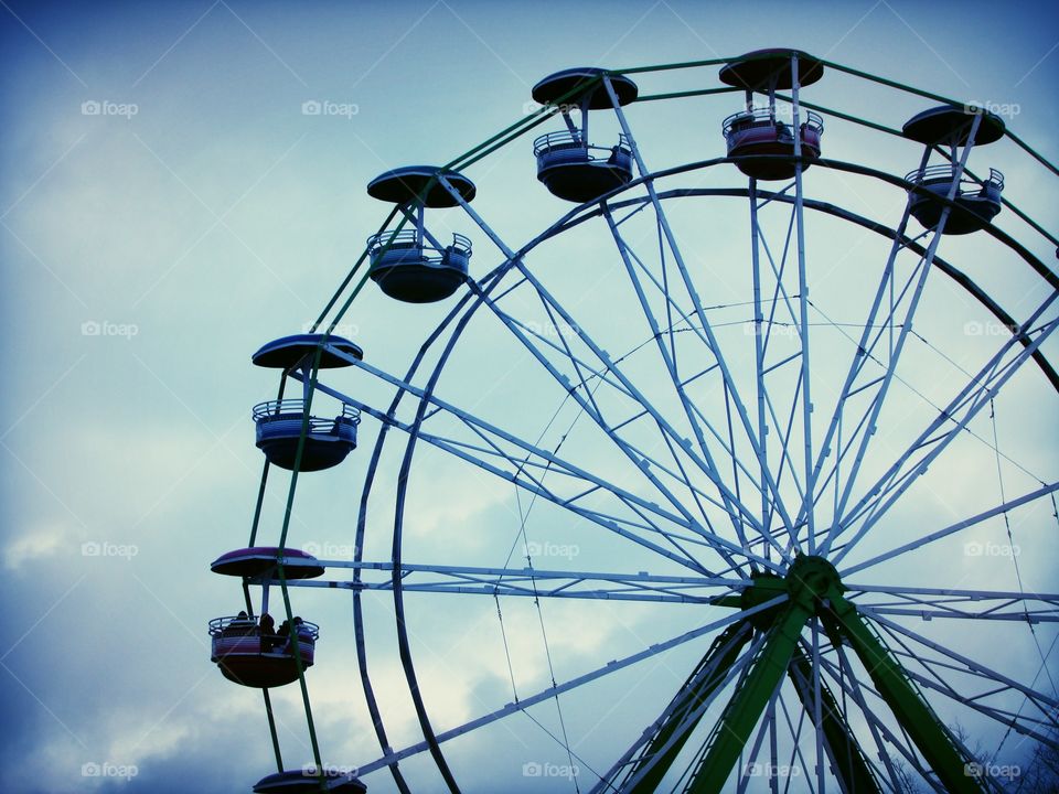 Ferris wheel on a cloudy sky