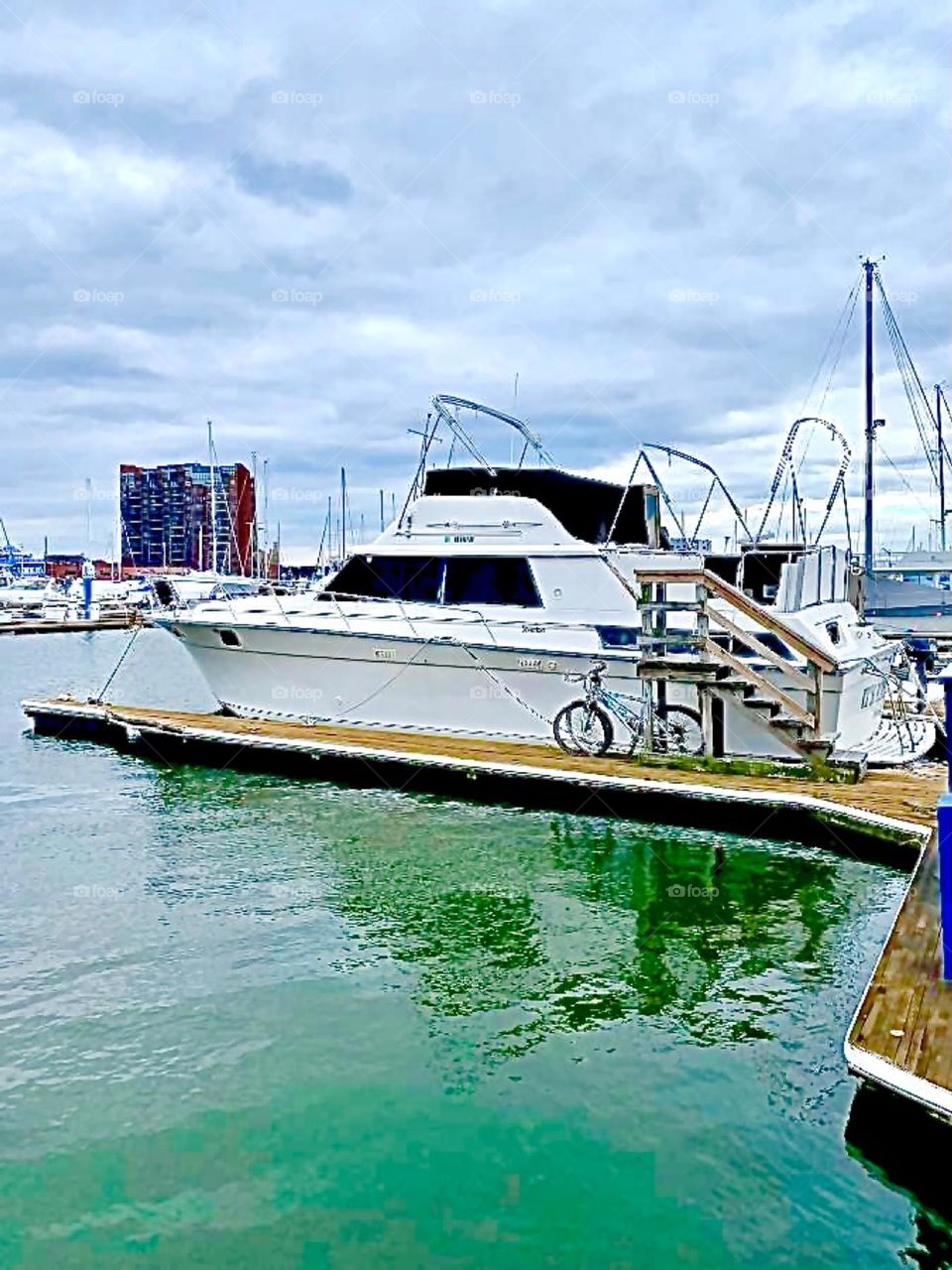 A boat in the waters of the East River with a bicycle next to it underneath an overcast cloudy sky photographed in 2020. Hypnotic Productions
