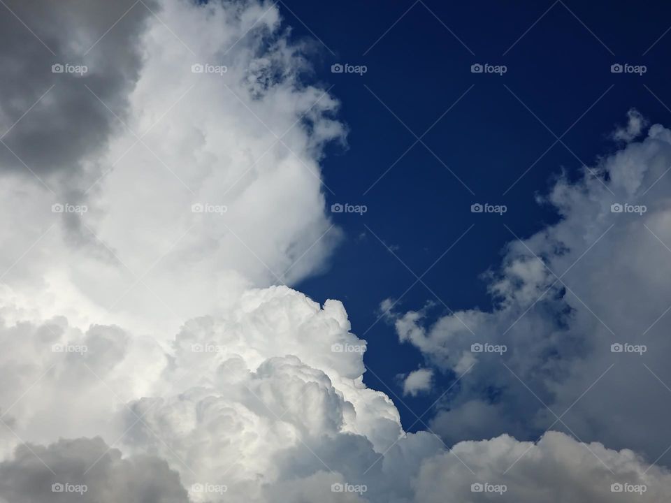 Dark blue sky with fluffy clouds