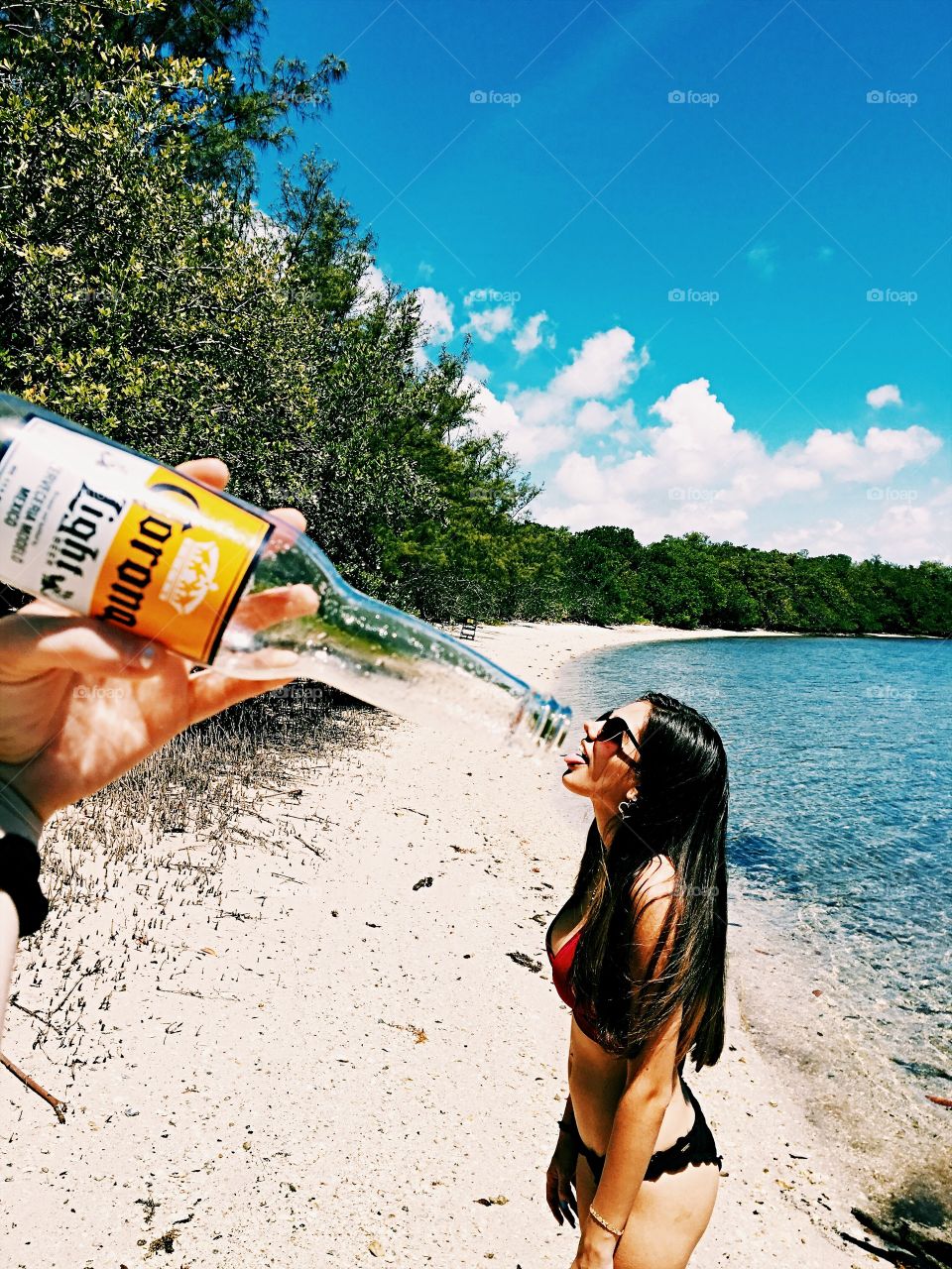 Woman drinking beer from bottle at sea side