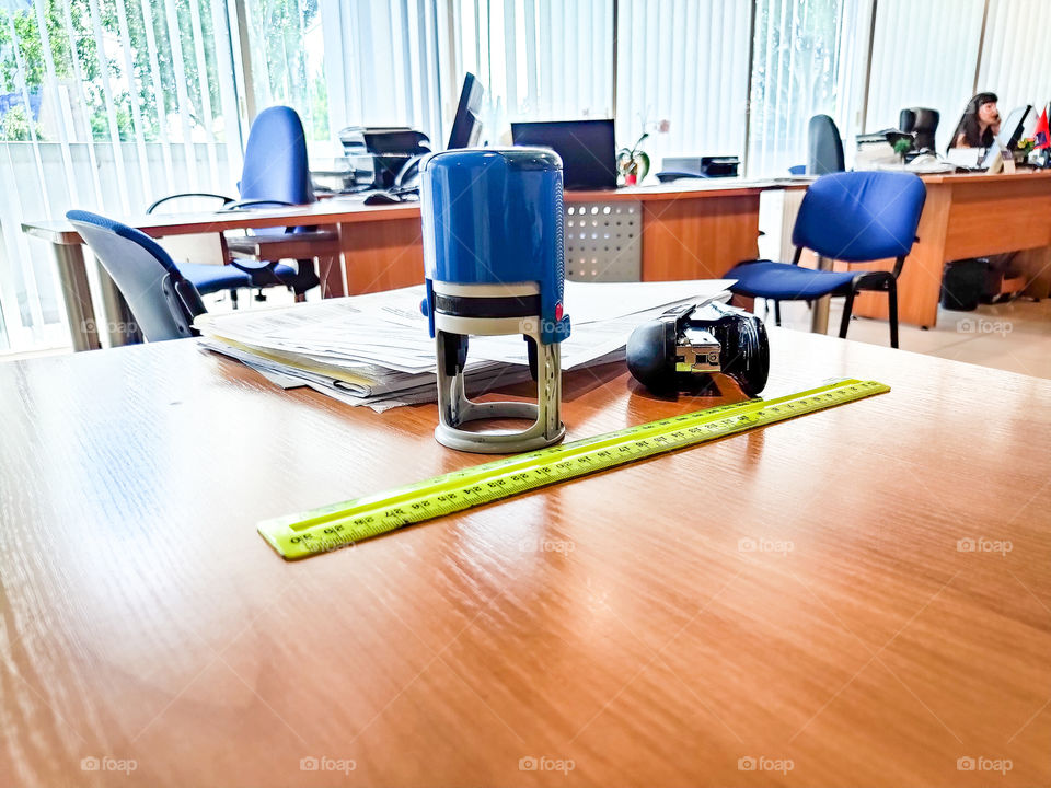 still life on the office desk.  Stamp, ruler, stack of papers and stapler