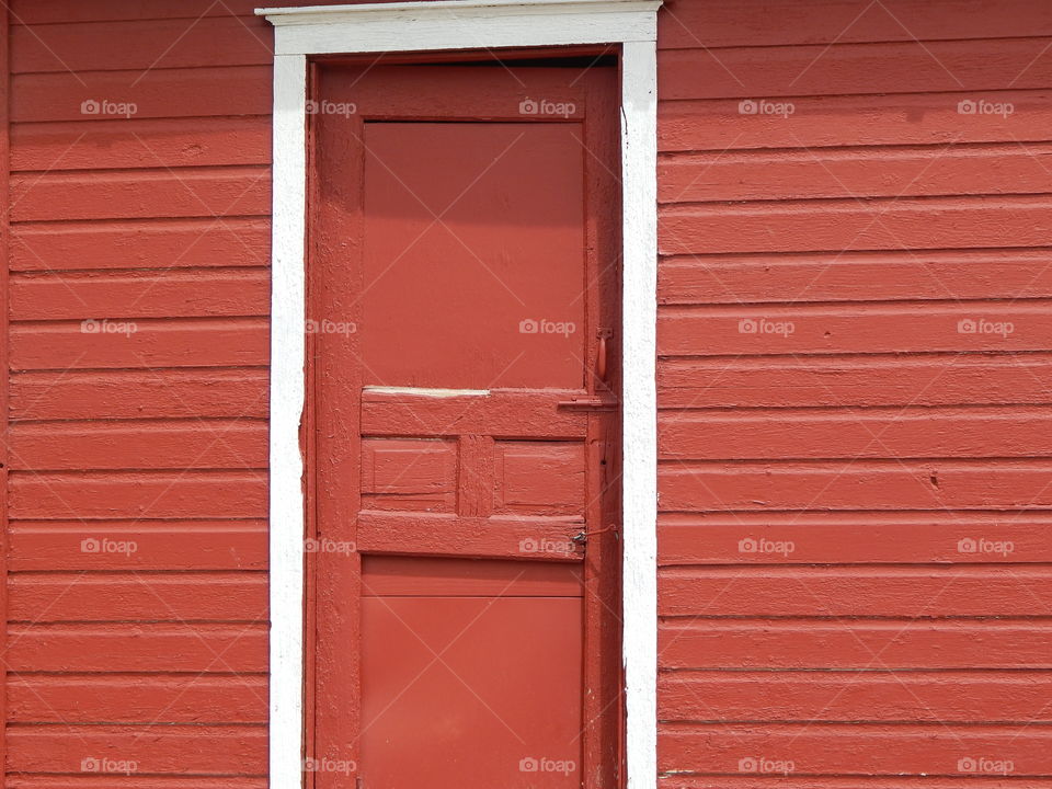 Red building door. Symbol of life on the farm.