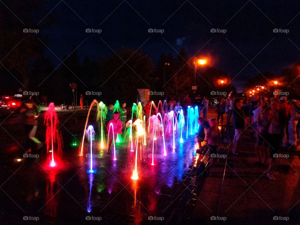 LED lights water fountain attracting people in nightlife