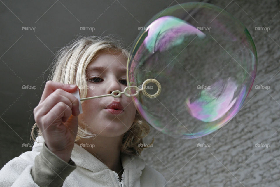 girl blowing soap balloon