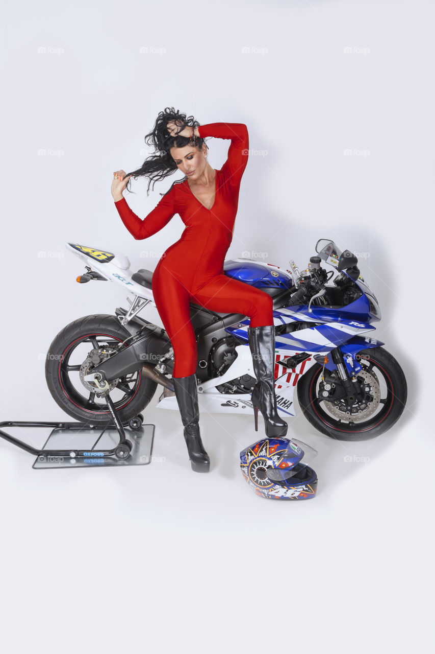 Female model posing with motorcycle on white background