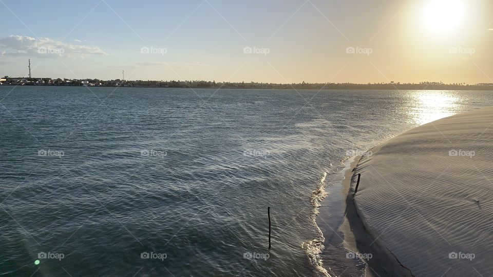 White dunes and sea river at sunset 