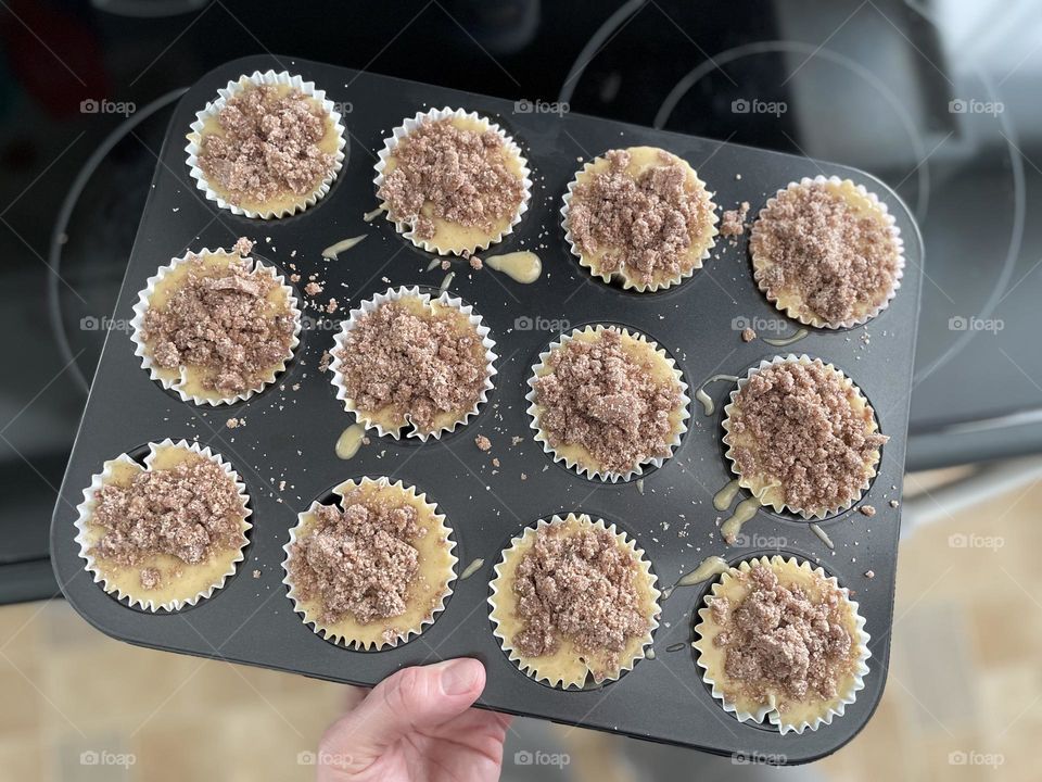 Circular muffin pan filled with batter, woman putting muffins into oven to bake, making cinnamon streusel muffins at home, circular shapes in everyday life, circles in our lives, geometric shapes in everyday life, baking in the kitchen, homemade yum