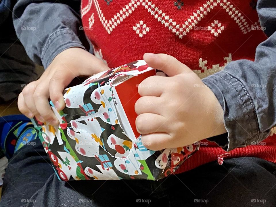 Child hand unwrapping gift 