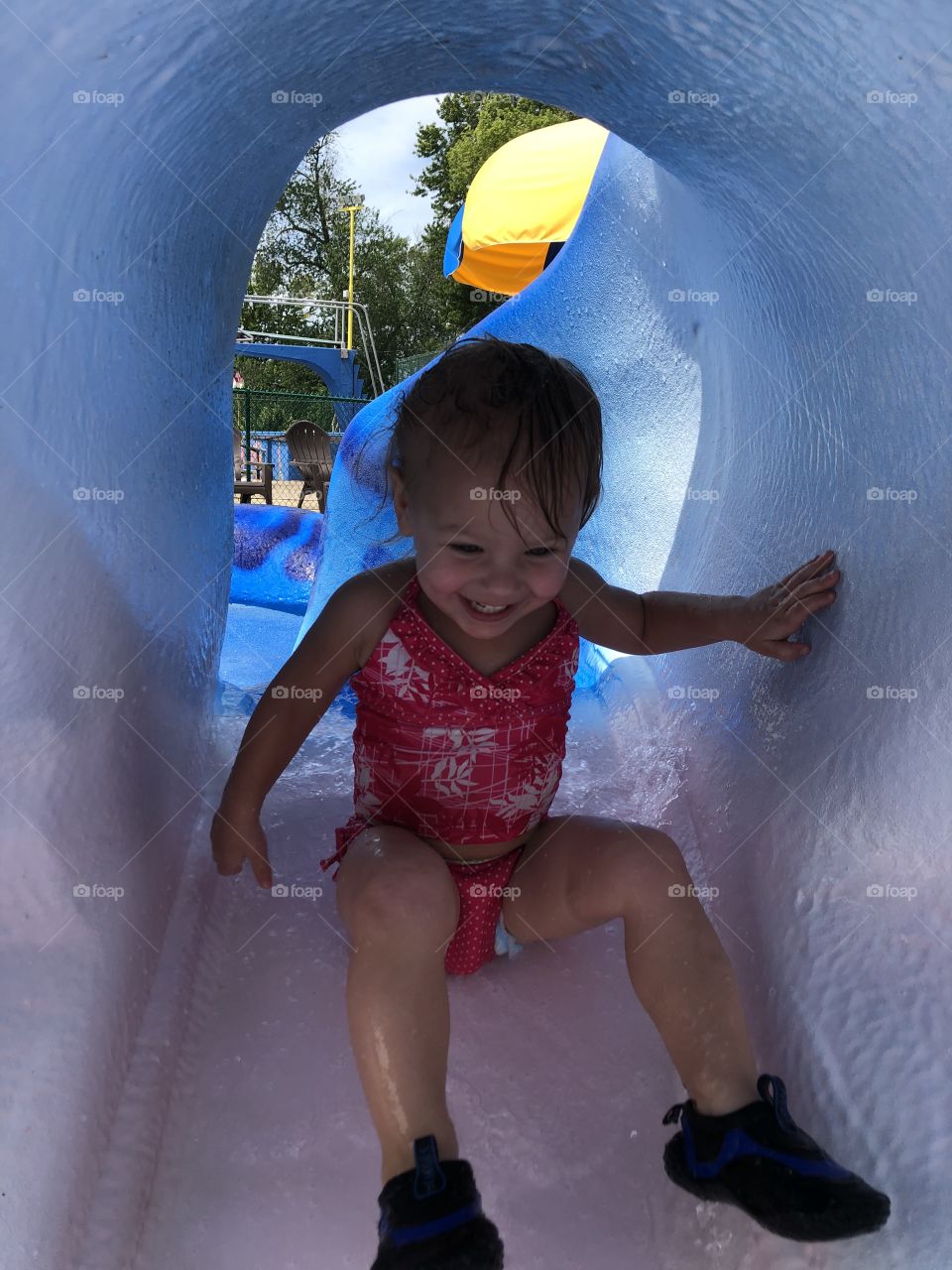 Toddler girl going down a water slide