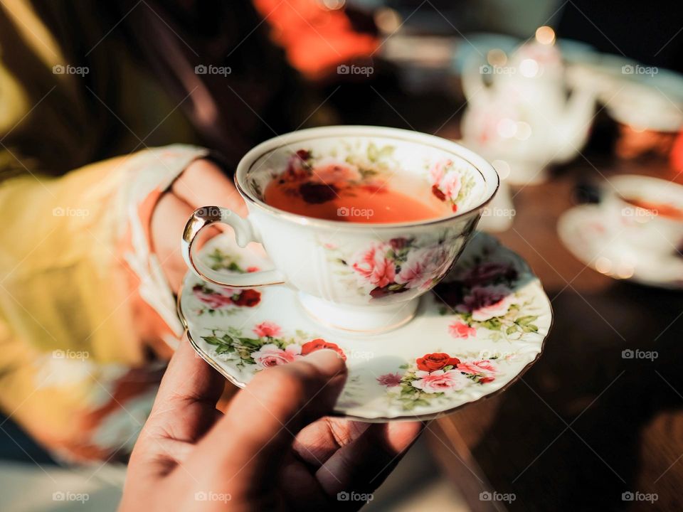 Serving  a hot tea in a beautiful porcelain cup set in the evening light