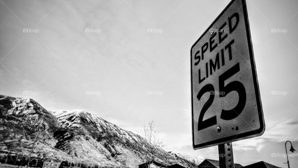 A speed limit sign with mountain behind.
