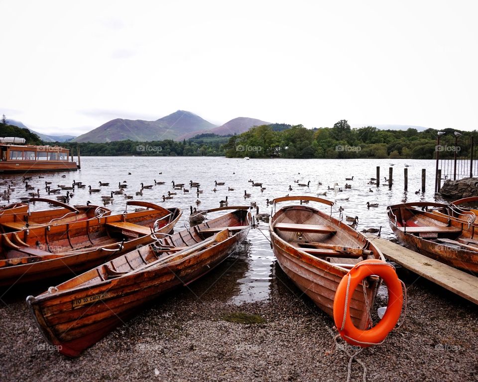 Rowing boats on the shore by Derwentwater, England. 